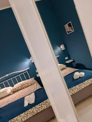two beds in a room with blue walls at Le case di Caterina in Palermo