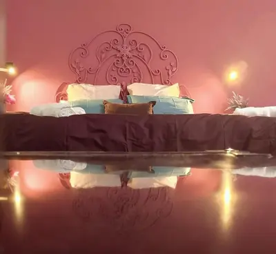a bedroom with a bed with its reflection in the water at Le case di Caterina in Palermo