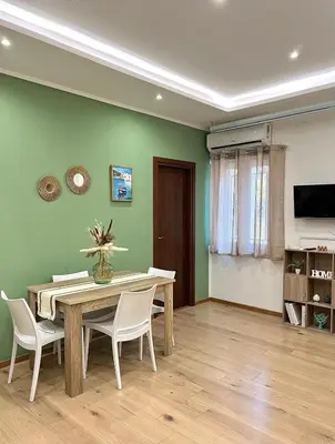 a dining room with a wooden table and chairs at Cocciu D'Amuri Apartment in Palermo