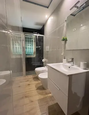 a bathroom with a sink and a toilet and a shower at Cocciu D'Amuri Apartment in Palermo