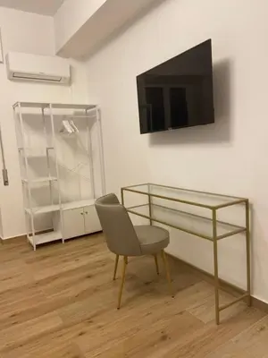 a room with a chair and a tv on a wall at La Zisa Luxury Apartment in Palermo