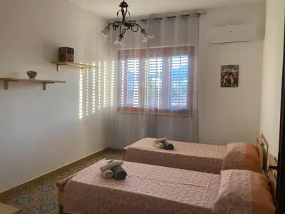 a bedroom with two beds and a window at House of Lady in Carini