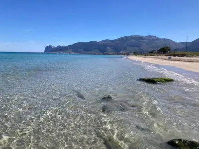 a beach with some rocks in the water at House of Lady in Carini