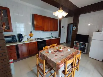 a kitchen with a table with chairs and a refrigerator at House of Lady in Carini