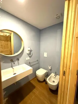 a bathroom with a sink and a toilet and a mirror at Cala Peppa Apartments in Palermo