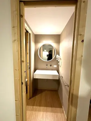 a man taking a picture of a bathroom with a sink at Cala Peppa Apartments in Palermo