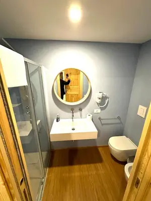 a bathroom with a sink and a mirror and a toilet at Cala Peppa Apartments in Palermo