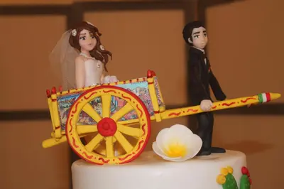 a bride and groom figurines on top of a wedding cake at Hotel Conchiglia d'Oro in Mondello
