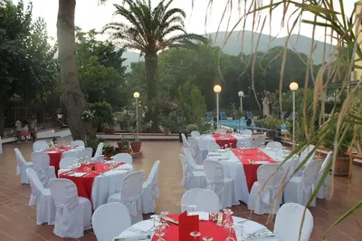 a group of tables and chairs with red and white table settings at Hotel Conchiglia d'Oro in Mondello