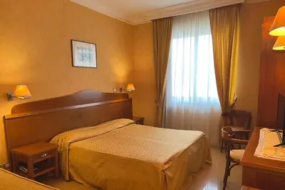 a hotel room with a bed and a window at Hotel Conchiglia d'Oro in Mondello