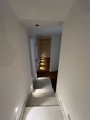 a hallway with stairs leading to a room with a door at Marina Boutique Rooms in Carini