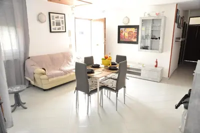 a living room with a table and chairs and a couch at La Via Del Mare in Partinico