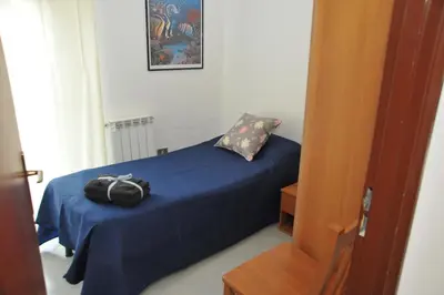 a bedroom with a blue bed with a bag on it at La Via Del Mare in Partinico