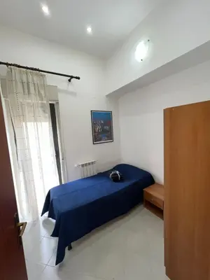 a bedroom with a blue bed and a window at La Via Del Mare in Partinico