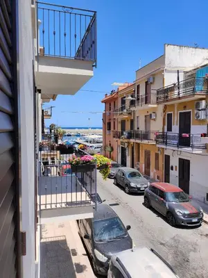 a balcony of a building with cars parked on a street at Casa3Fratelli, via Cutino 16 in Isola delle Femmine