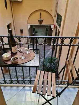 a balcony with a table and a bottle of wine at Casa e Putia Apartment in Palermo
