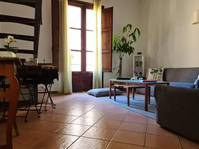 a living room with a couch and a table and a piano at Casa e Putia Apartment in Palermo