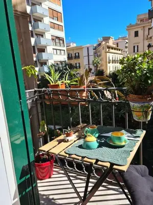 a table with cups and saucers on a balcony at Casa e Putia Apartment in Palermo