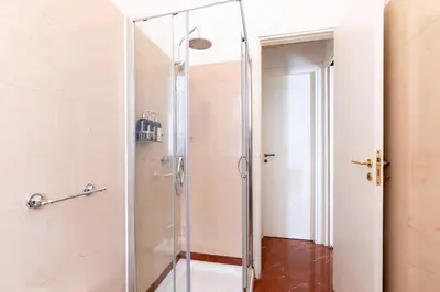 a shower with a glass door in a bathroom at Diletti Rooms in Palermo