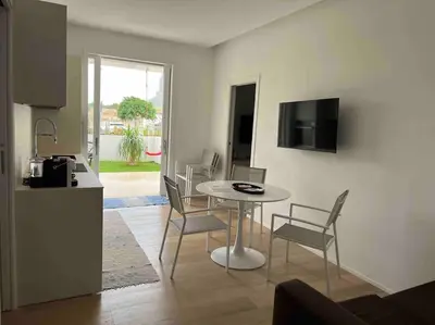 a kitchen and a table and chairs in a room at Villa Ippolita - 2 Bedrooms Apartment with Exclusive Garden in San Vito lo Capo