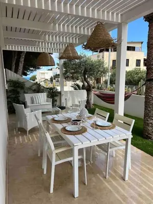 a white table and chairs on a patio at Villa Ippolita - 2 Bedrooms Apartment with Exclusive Garden in San Vito lo Capo