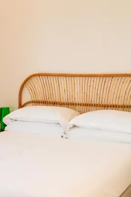 a bed with a wooden headboard and white pillows at Villa Ippolita - 2 Bedrooms Apartment with Terrace & Garden Exclusive in San Vito lo Capo