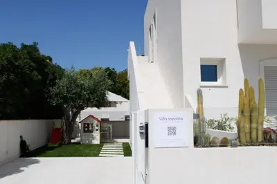 a white house with a white fence and a yard at Villa Ippolita - 2 Bedrooms Apartment with Terrace & Garden Exclusive in San Vito lo Capo