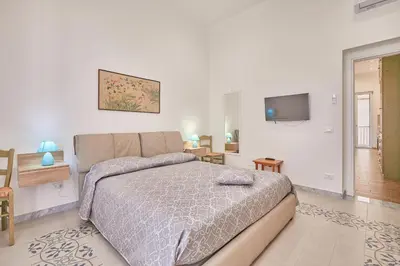 a bedroom with a bed and a flat screen tv at Zia Marì Casa Vacanze in Palermo