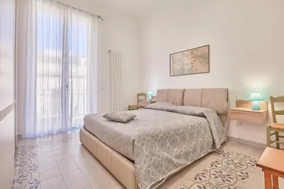 a bedroom with a bed and a large window at Zia Marì Casa Vacanze in Palermo