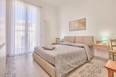 a bedroom with a bed and a large window at Zia Marì Casa Vacanze in Palermo
