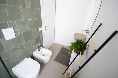 a bathroom with a white toilet and a sink at iFlat Porta di Mare 45 in Palermo