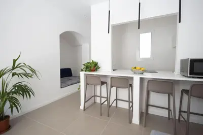 a kitchen with a white counter and stools at iFlat Porta di Mare 45 in Palermo