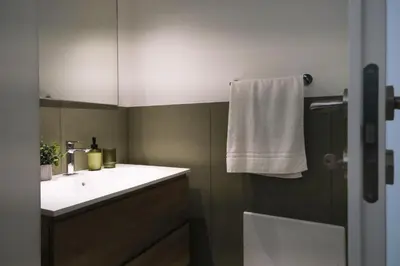 a bathroom with a white sink and a white towel at Ai Materassai Apartments Palermo in Palermo