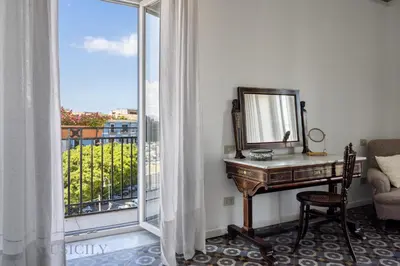 a mirror and a desk in a room with a window at Palazzo Fatta Apartment by DomuSicily in Palermo