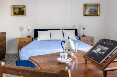 a bedroom with a bed and a tea set on a table at Palazzo Fatta Apartment by DomuSicily in Palermo