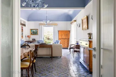 a dining room and living room with a table and chairs at Palazzo Fatta Apartment by DomuSicily in Palermo