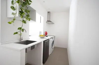 a white kitchen with a sink and a dishwasher at iFlat Porta di Mare 49 in Palermo