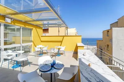 a patio with tables and chairs and the ocean at B&B La Dimora di Poseidone in Bagheria
