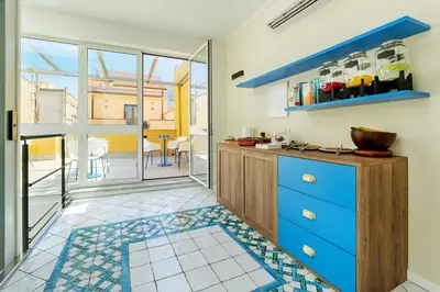a kitchen with blue cabinets and a view of a patio at B&B La Dimora di Poseidone in Bagheria