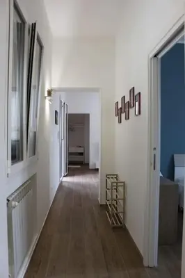 a hallway with white walls and a wooden floor at Zia Pina Home in Palermo