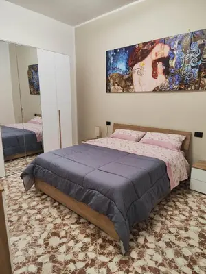 a bedroom with a bed and a large painting on the wall at Casa Donna Caterina e Don Paolo in Bagheria