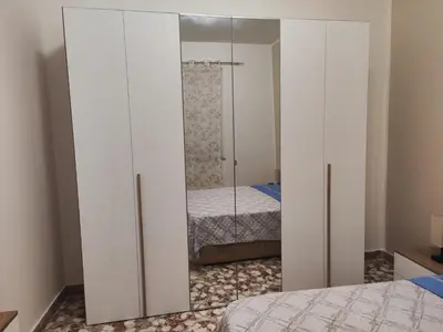 a bedroom with white cabinets and a bed at Casa Donna Caterina e Don Paolo in Bagheria