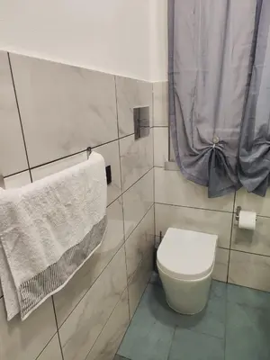 a bathroom with a toilet and towels on the wall at Casa Donna Caterina e Don Paolo in Bagheria