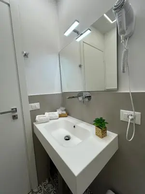 a bathroom with a white sink and a mirror at Palermo Centro Affittacamere Spina in Palermo