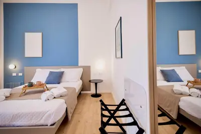 two beds in a room with blue walls at Politeama Charming Apartment in Palermo