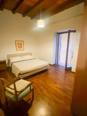 a bedroom with a bed and a chair in it at La discesa di San Giuseppe in Termini Imerese