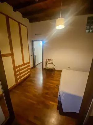 a bedroom with a bed and a chair in a room at La discesa di San Giuseppe in Termini Imerese
