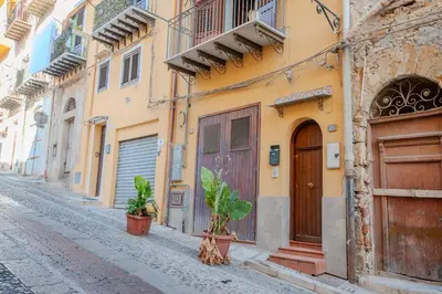 an alley in an old town with buildings at La discesa di San Giuseppe in Termini Imerese