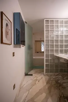 a bathroom with glass block walls and a refrigerator at Palermo 3 bedrooms apartment historic center in Palermo