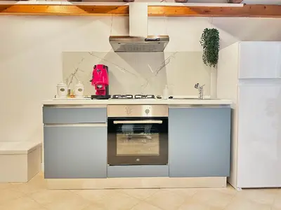 a kitchen with a stove top oven next to a refrigerator at Siloe Apartment Palermo in Palermo